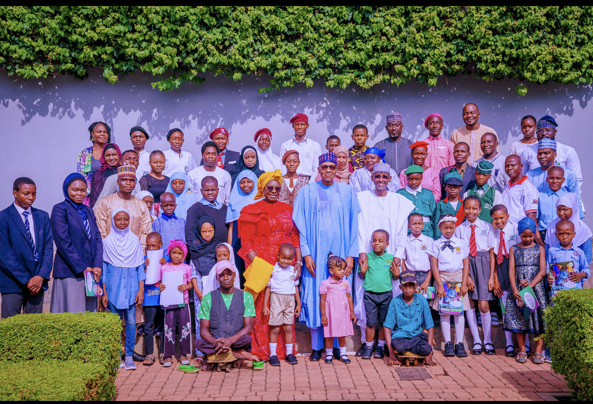 Minister of Women Affairs Pauline Tallen, Minister of FCT Muhammad Bello and President Muhammadu Buhari in a group photograph with children he hosted on Children’s Day