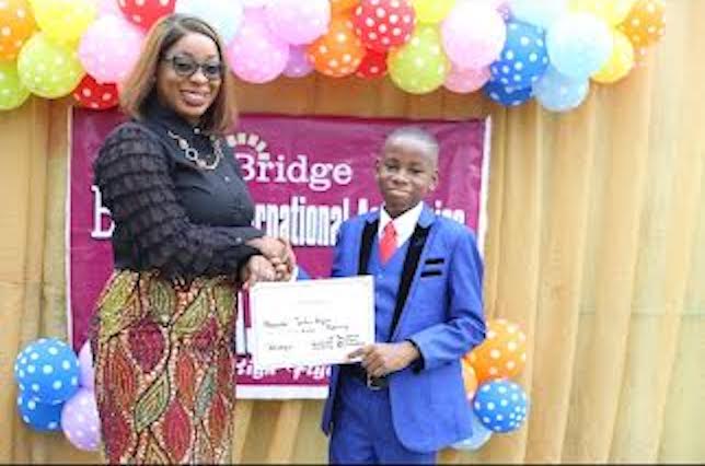 L-R: Foyinsola Akinjayeju, Managing Director, Bridge International Academies Nigeria presenting Alexander with a certificate of recognition