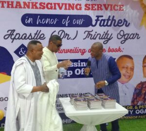 Deputy Governor Odey (middle), Apostle Ogar (left) and Bishop Isong (right) unveiling the book at Gold City Church Calabar, Cross River