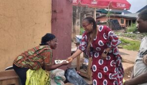Mrs Chidoka handing over cash to a beneficiary