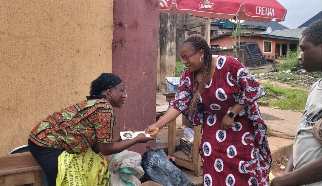 Mrs Chidoka handing over cash to a beneficiary