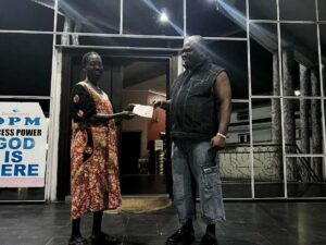 Apostle Chibuzor Gift Chinyere presenting N1 million to Mrs. Esther Ogu