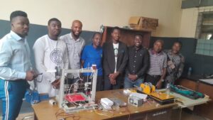 Prof. Akor (middle) with others showcasing the 3D printer and filament machine