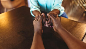 Photo of a man and woman holding hands at a table