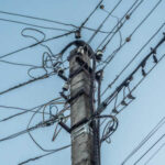 165657537-the-old-concrete-electric-support-is-chaotically-hung-with-many-wires-close-up
