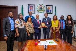 Enugu Governor Peter Obi (centre left) presented with a plaque by Emeka Eleh of estate surveyor group Ubosi Eleh and Co on Wednesday, June 26, 2024, at Government House, Enugu