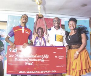 •L-R- Chika Onwuatuogu, a judge; Aderibigbe Emmanuel, the winner; Emeka Onyejiaka, and Catherine Onyejiaka, both judges, at the presentation of mock cheque and trophy to Emmanuel