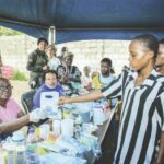 A medical volunteer, Nimi Oruambo (left), handing over medication to a beneficiary during the event