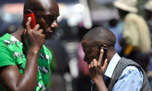 People use mobile phones in Nairobi, Kenya. There are about 700m sim cards in Africa.