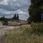 Ukrainian servicemen ride military vehicles from a crossing point at the border with Russia in Sumy region