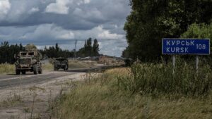 Ukrainian servicemen ride military vehicles from a crossing point at the border with Russia in Sumy region