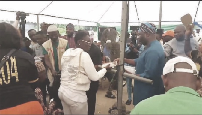 •Salawu presenting palliative to one of the beneficiaries