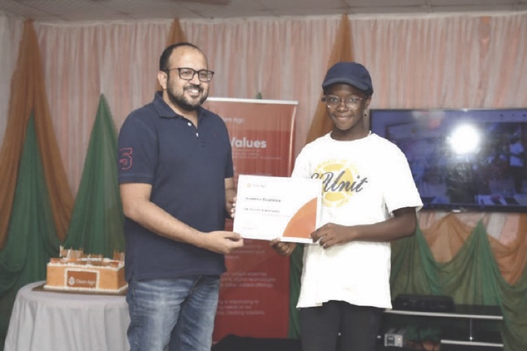 Umer Hayat, general manager, animal feed segment, Olam Agri (right), presenting a Back-to-School scholarship award certificate to Obi Amarachukwu, a beneficiary of the initiative, recently, in Ilorin.