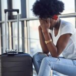Young African woman sitting in airport terminal
