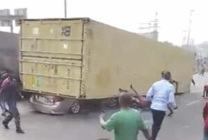 Fallen container with Toyota Camry underneath.