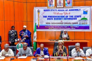 Niger State Governor Umaru Bago (far left, background) giving a speech in the chambers of the state House of Assembly after presenting the 2025 budget to the state legislature