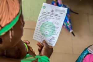 POV photograph of a woman holding and reading a birth certificate