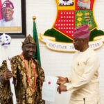 46th Alaafin-elect Prince Akeem Abimbola Owoade (L) being presented staff of office by Oyo Governor Seyi Makinde (R) in Ibadan