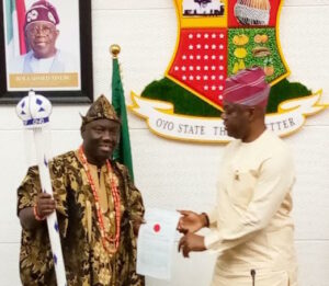 46th Alaafin-elect Prince Akeem Abimbola Owoade (L) being presented staff of office by Oyo Governor Seyi Makinde (R) in Ibadan