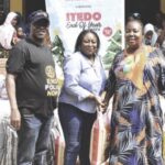 Elusakin and Past President, Ifeoma Anieze Corona presenting a bag of rice to a staff of the school