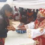 Okwor presenting cash gift to a beneficiary