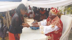 Okwor presenting cash gift to a beneficiary