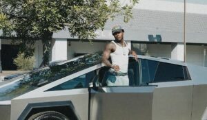 Asake poses with new Tesla vehicle