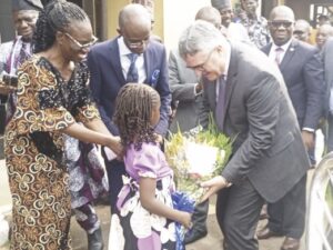 Nfor Raphaella Esther present flower bouquet to Kohler. Prof. Tayo and others watch
