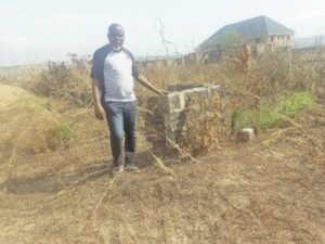 Nwonu standing at his plot of land before the dispute
