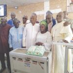 Prophet Ibirongbe with wife and church members cutting the anniversary cake