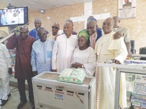 Prophet Ibirongbe with wife and church members cutting the anniversary cake