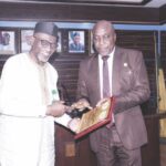Alexander (right) hands over books on ICPC activities to Dr. Abdul (left)