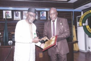 Alexander (right) hands over books on ICPC activities to Dr. Abdul (left)