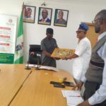 Dr. Festus Alenkhe (r)presenting an effigy of the Last Super to the Executive Chairman of the EIRS, Mr. Bankole Balogun (l) during the visit in Benin City