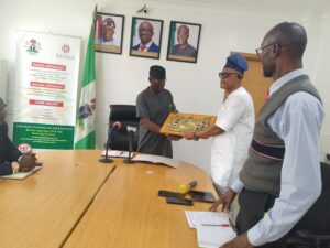 Dr. Festus Alenkhe (r)presenting an effigy of the Last Super to the Executive Chairman of the EIRS, Mr. Bankole Balogun (l) during the visit in Benin City