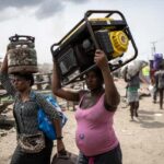 Residents carry their belongings after the demolition of a Lagos suburb, 2025. Olympia De Maismont/AFP via Getty Images