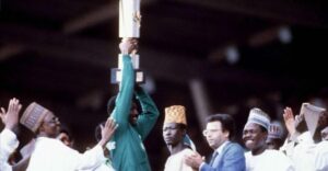 • Chukwu (second from left) hoists the Unity Cup above his head after receiving it from President Shehu Shagari (left) on Saturday, 22nd March 1980. All the players received the national award of Member of the Order of the Niger (MON).