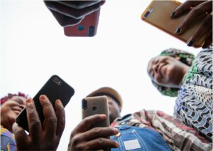 Group in a circle holding mobile phones viewed from the ground up