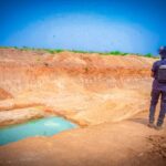 Mining Marshal in Zamfara looks at a shallow pool