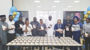 Ndidi (fourth from left) with guests displaying copies of her book during the programme