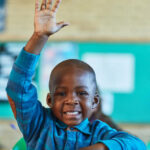 Cropped shot of an elementary school boy hand raised in the classroom