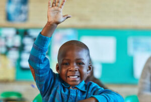 Cropped shot of an elementary school boy hand raised in the classroom