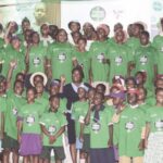 Abikoye (middle) surrounded by school pupils at the event
