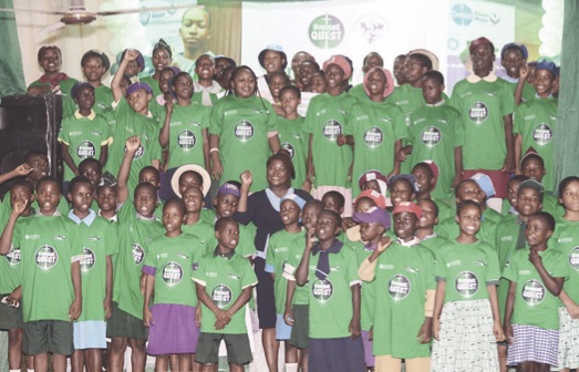 Abikoye (middle) surrounded by school pupils at the event
