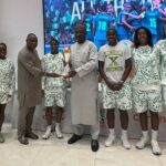 Carloha Nigeria MD, Mr. Sola Adigun, NFF President, Alhaji Ibrahim Musa Gasau (wearing a cap), and the Super Falcons players, show off the WAFCON trophy at the Chery showroom in Alapere, Lagos, recently