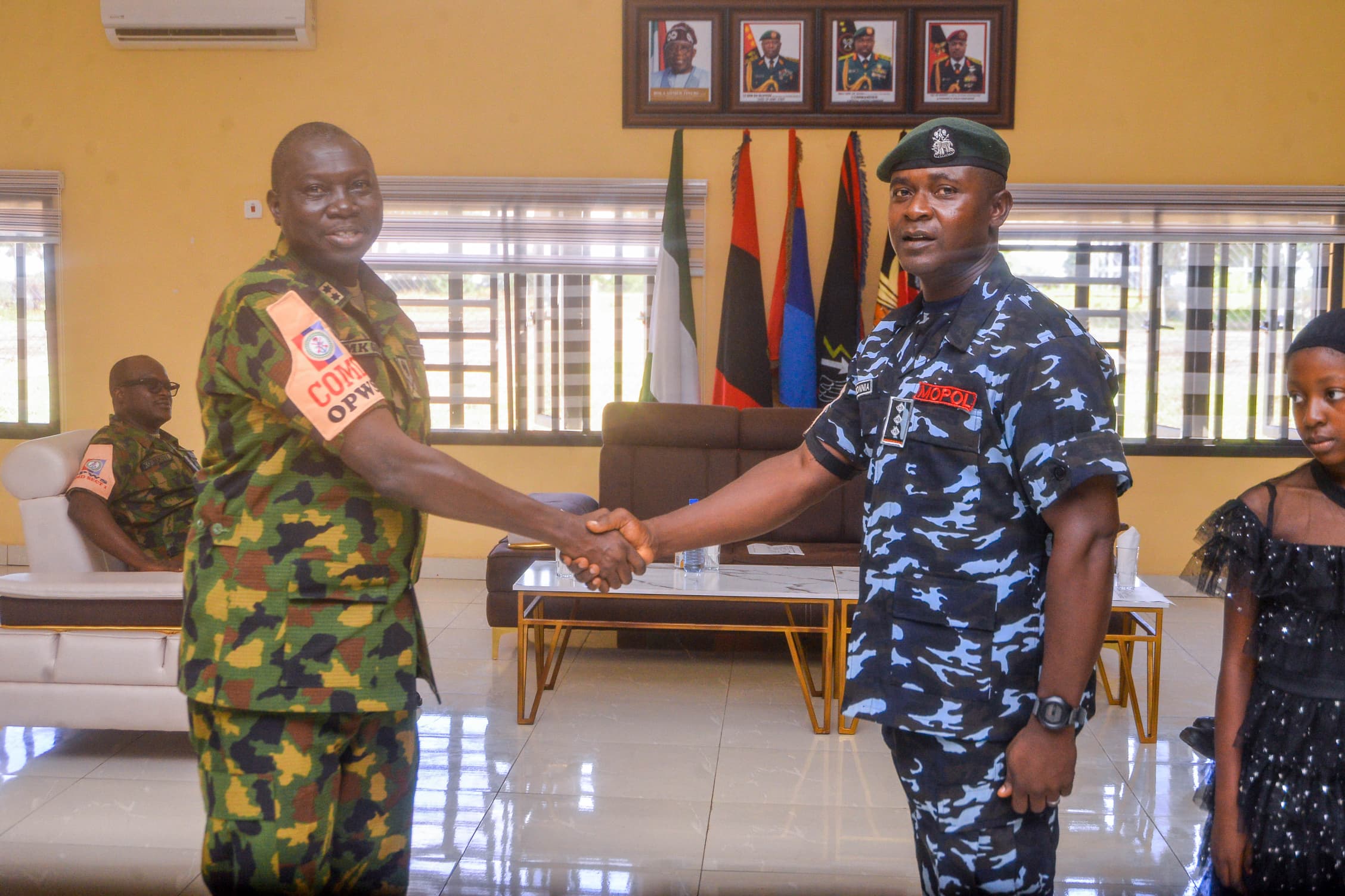 Force Commander, OPWS, Moses Gara, in a handshake with one of the promoted officers