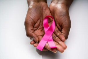 Human Hand Showing Pink Ribbon To Support Breast Cancer Cause