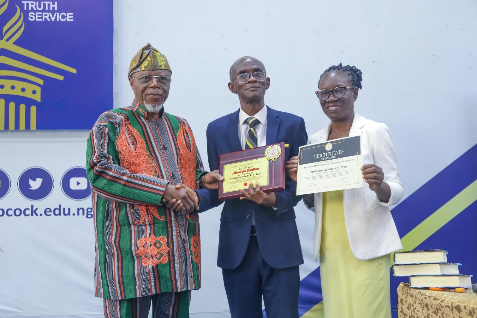 Prof. Ademola (middle) receives handshake and award from Prof. Falola (left) and VC’s wife, Prof. Grace Tayo at the lecture