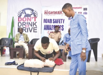 A Red Cross official simulates resuscitation of an accident victim at the scene of a road crash
