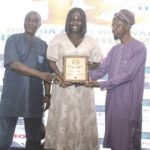 Marketing Manager, Kia Nigeria, Omolade Akinyode (middle), receiving the Compact SUV award (won by Kia Seltos) at the 2025 NAJA Awards